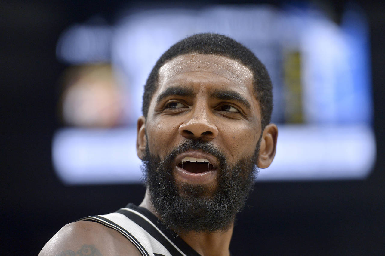 FILE - Brooklyn Nets guard Kyrie Irving reacts in the second half of an NBA basketball game against...