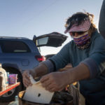 
              Karlene Goodluck places dough in oil to make Navajo fry bread outside of the Churchrock Chapter House in Church Rock, N.M., on Election Day, Tuesday, Nov. 8, 2022. (AP Photo/William C. Weaver IV)
            