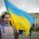 
              A young woman wearing a traditional folk flower wreath holds a Ukrainian flag in central Kherson, Ukraine, Sunday, Nov. 13, 2022. The Russian retreat from Kherson marked a triumphant milestone in Ukraine's pushback against Moscow's invasion almost nine months ago. (AP Photo/Efrem Lukatsky)
            