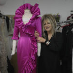 
              British designer Elizabeth Emanuel stands beside a replica of an evening gown she designed for then-Lady Diana Spencer to wear at a Buckingham Palace party a few days before her marriage to Prince Charles in 1981, in London, Friday, Nov. 18, 2022. Emanuel recreated the dress for her own archive and to show another side of Diana, who Emanuel believes has been misrepresented by "The Crown," the popular Netflix series that has brought the story of the princess and her ill-fated marriage to a new generation. (AP Photo/Kin Cheung)
            