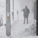 
              A person walks through downtown in the snow Friday, Nov. 18, 2022, in Buffalo, N.Y.  A dangerous lake-effect snowstorm paralyzed parts of western and northern New York, with nearly 2 feet of snow already on the ground in some places and possibly much more on the way.  (AP Photo/Joshua Bessex)
            