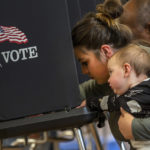 
              Miranda Padilla holds her 11-month-old son Grayson Sanchez while marking her ballot at a polling center in the South Valley area of Albuquerque, N.M., Tuesday, Nov. 8, 2022 (AP Photo/Andres Leighton)
            