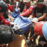 
              Rescuers remove the body of a victim recovered from under the rubble at a village affected by an earthquake-triggered landslide in Cianjur, West Java, Indonesia, Tuesday, Nov. 22, 2022. (AP Photo/Rangga Firmansyah)
            