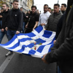 
              University students hold a blood-stained Greek flag from the deadly 1973 student uprising during a rally in Athens, Thursday, Nov. 17, 2022. Around 5,000 police were expected to be deployed in the Greek capital, where major streets were to be blocked to traffic and three subway stations along the march route shut down afternoon. In 1973, the military regime that had been in power since 1967 sent police and troops to crush student-led pro-democracy protests centered in the Athens Polytechnic. (AP Photo/Michael Varaklas)
            