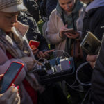 
              Residents gather next to an internet hotspot in Kherson, southern Ukraine, Monday, Nov. 14, 2022. The retaking of Kherson was one of Ukraine's biggest successes in the nearly nine months since Moscow's invasion. (AP Photo/Bernat Armangue)
            