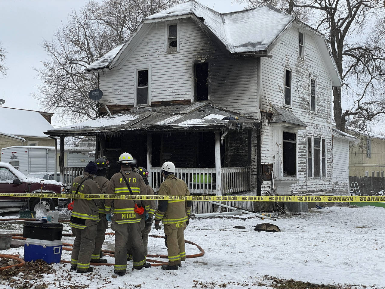 Mason City, Iowa, firefighters look on after containing a fire at a home on Washington Avenue in Ma...
