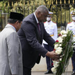 
              U.S. Secretary of Defense Lloyd Austin, center, lays a wreath as Indonesian Defense Minister Prabowo Subianto, left, looks on during a welcoming ceremony in Jakarta, Indonesia, Monday, Nov. 21, 2022. (AP Photo/Tatan Syuflana)
            