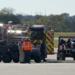 Emergency responders stage on the flightline at the Dallas Executive Airport where two vintage aircraft crashed during an airshow, Saturday, Nov. 12, 2022. (AP Photo/LM Otero)