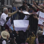 
              Mexican President Andres Manuel Lopez Obrador saya farewell after a march to the capital's main square, the Zócalo, where thousands met to show their support for his government, in Mexico City, Sunday, November 27, 2022. (AP Photo / Marco Ugarte)
            