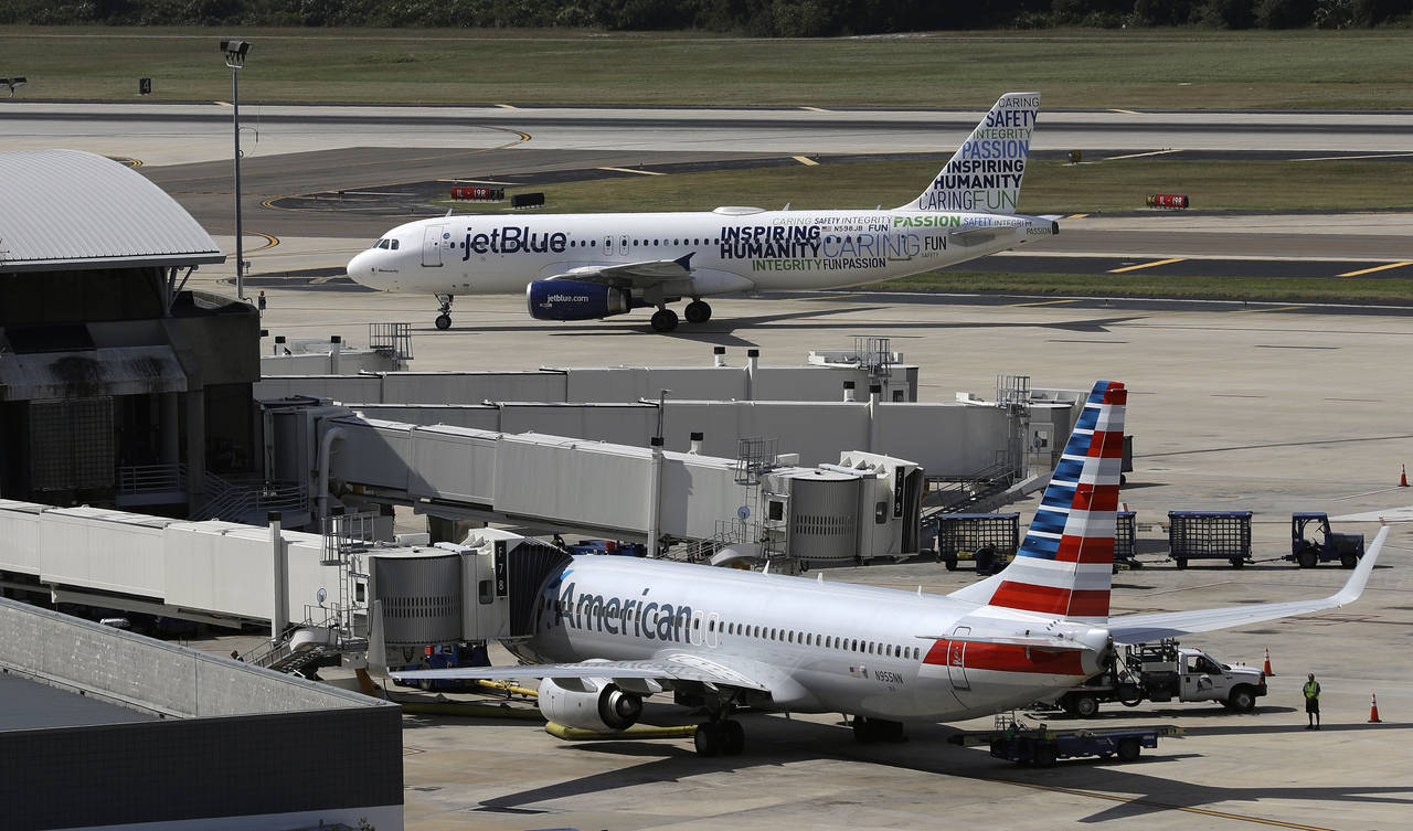 FILE - A JetBlue Airbus A320 taxis to a gate on Oct. 26, 2016, after landing, as an American Airlin...