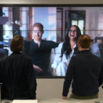 
              Office workers in London, watch the Duke and Duchess of Sussex's controversial documentary being aired on Netflix Thursday, Dec. 8, 2022. Britain’s monarchy is bracing for more bombshells to be lobbed over the palace gates as Netflix releases the first three episodes of a new series. The show “Harry & Meghan” promises to tell the “full truth” about Prince Harry and his wife Meghan’s estrangement from the royal family. The series debuted Thursday. (Jonathan Brady/PA via AP)
            