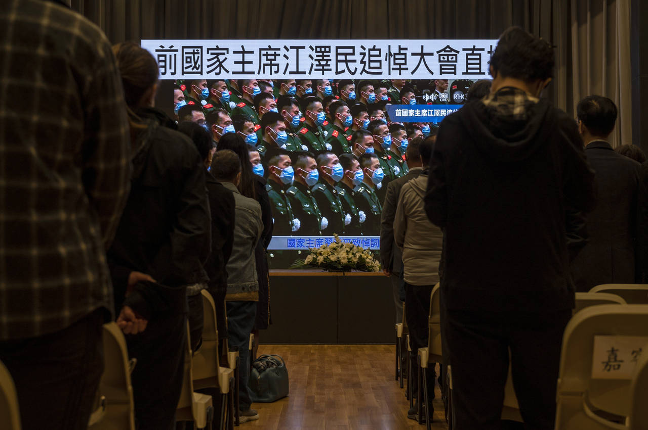 Residents watch a live broadcast of the memorial service for late former Chinese President Jiang Ze...