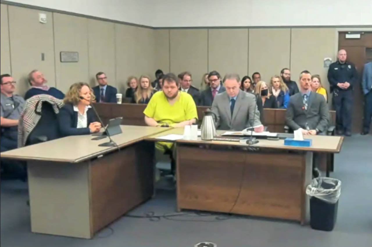In this image taken from El Paso County District Court video, Anderson Lee Aldrich, 22, center, sit...