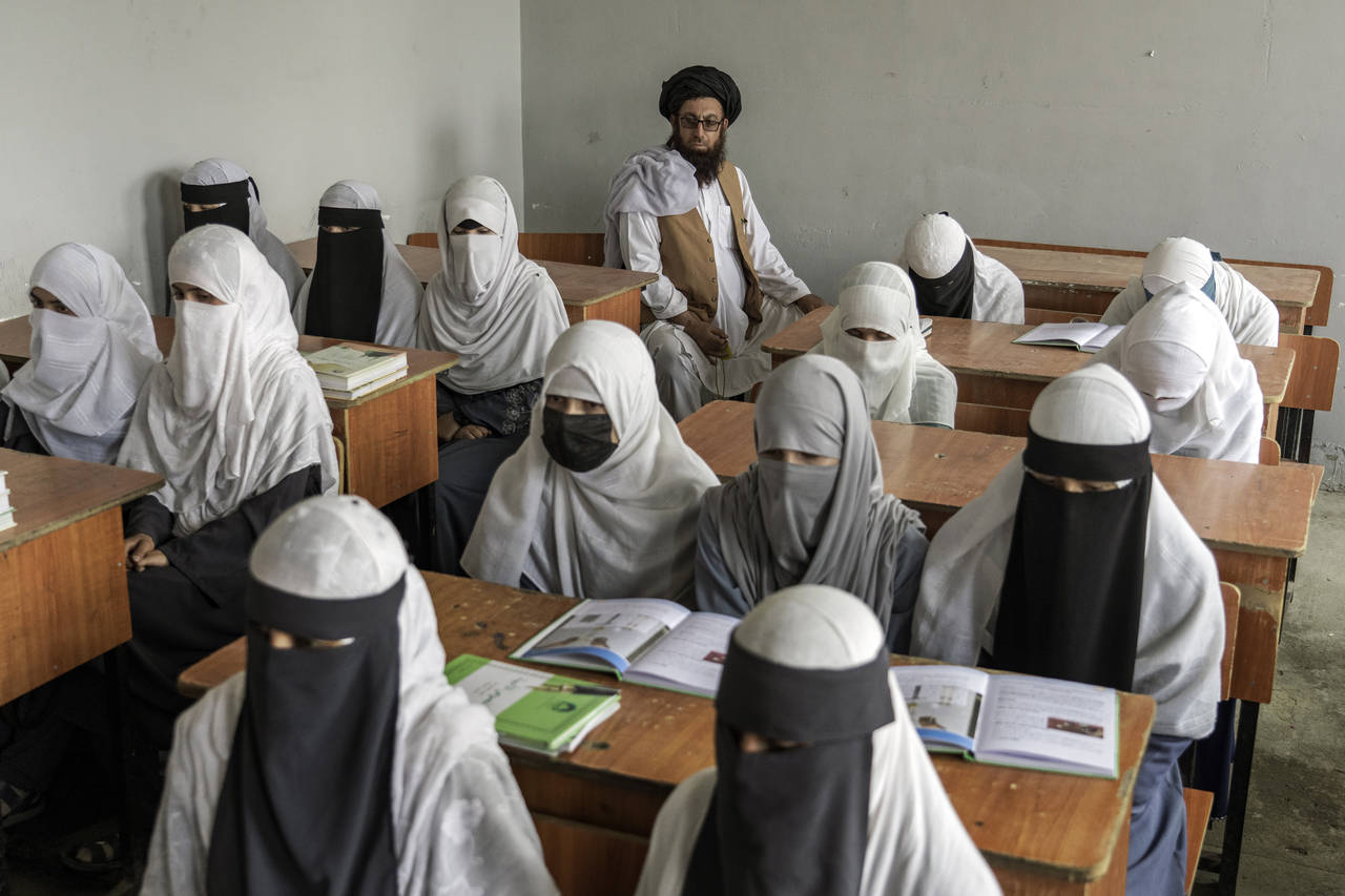 FILE- Afghan girls attend a religious school, which remained open since the last year's Taliban tak...