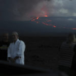 
              Spectators take photos as they watch the lava flow down the mountain from the Mauna Loa eruption, Tuesday, Nov. 29, 2022, near Hilo, Hawaii. (AP Photo/Marco Garcia)
            