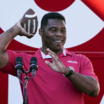 
              Republican candidate for U.S. Senate Herschel Walker throws a football to a supporter during a campaign rally Tuesday, Nov. 29, 2022, in Greensboro, Ga. Walker is in a runoff election with incumbent Democratic Sen. Raphael Warnock. (AP Photo/John Bazemore)
            