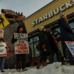 
              Starbucks workers hold signs in front of a giant inflatable mouse during the "Unfair Labor Practice Strike." in St. Paul, Minn. on Friday, Dec. 16, 2022. Starbucks workers around the U.S. are planning a three-day strike starting Friday. The walkouts are part of their effort to unionize the coffee chain's stores.(Kerem Yücel /Minnesota Public Radio via AP)
            