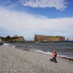 
              People walk along the beach with Perce Rock in the distance in Perce, Quebec, Canada, Wednesday, Sept. 14, 2022. After devastating winter storms several years ago that officials tied to climate change, they replenished the pebbles on the beach and let the sea shape them into a gentler slope to help absorb the impact of the waves. (AP Photo/Carolyn Kaster)
            