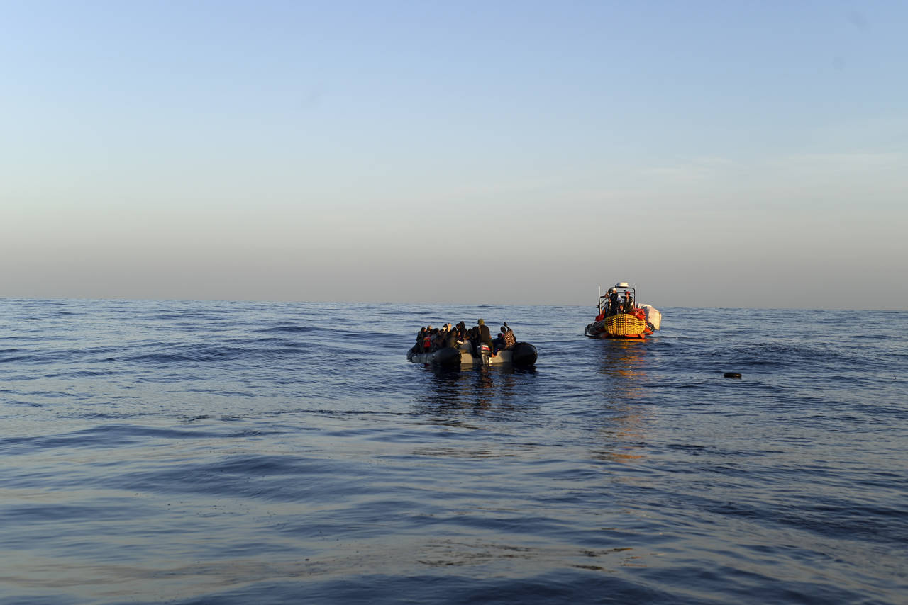 A MSF, Doctors Without Borders, humanitarian organization rescue team approaches a rubber boat with...