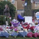 
              A woman lays flowers among the tributes near to Babbs Mill Park in Kingshurst, Solihull, Tuesday Dec. 13, 2022 after the deaths of three boys aged eight, 10 and 11 who fell through ice into a lake in the West Midlands. (Jacob King/PA via AP)
            