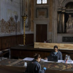 
              Restorers Annalisa Tosatto, right, and Alice Chiodelli work at the conservation and study of ' The reward and a pair of putti', a 1590 painting by Venetian Renaissance artist Andrea Michieli known as Andrea Vicentino in a makeshift laboratory set up in the Venetian Doge's private chapel inside Palazzo Ducale in Venice, northern Italy, Wednesday, Dec. 7, 2022. The 93x330 centimeters (approximately 36.6x130 inches) canvas was adorning the Grimani's Hall in the Doge's apartments of Palazzo Ducale. In the background Jacopo Sansovino's marble statue 'Madonna with child and angels'(1536-37). (AP Photo/Domenico Stinellis)
            