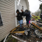 
              People help each other through the rubble after a tornado tore through the area in Killona, La., about 30 miles west of New Orleans in St. James Parish, Wednesday, Dec. 14, 2022. (AP Photo/Gerald Herbert)
            