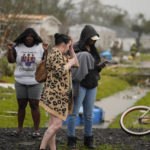 
              Residents stand outside destroyed homes from a tornado that tore through the area in Killona, La., about 30 miles west of New Orleans in St. James Parish, Wednesday, Dec. 14, 2022. (AP Photo/Gerald Herbert)
            