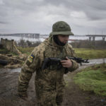 
              A Ukrainian serviceman patrols area near the Antonovsky Bridge which was destroyed by Russian forces after withdrawing from Kherson, Ukraine, Thursday, Dec. 8, 2022. (AP Photo/Evgeniy Maloletka)
            