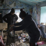 
              FILE - A family look through their possessions at their house which was occupied by Russian forces, in recently liberated village of Pravdyne, Kherson region, Ukraine, Tuesday, Dec. 6, 2022.  Russian invaders left behind all sorts of trickery as they fled this southern city to jubilation across Ukraine a month ago, and they continue to strike it from afar. (AP Photo/Evgeniy Maloletka, File)
            