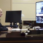 
              Russian President Vladimir Putin oversees the commissioning of new ships for the Russian navy via video conference at the Novo-Ogaryovo residence outside Moscow, Russia, Thursday, Dec. 29, 2022. Russian Defense Minister Sergei Shoigu is seen on the tv screen on the right. (Mikhail Klimentyev, Sputnik, Kremlin Pool Photo via AP)
            