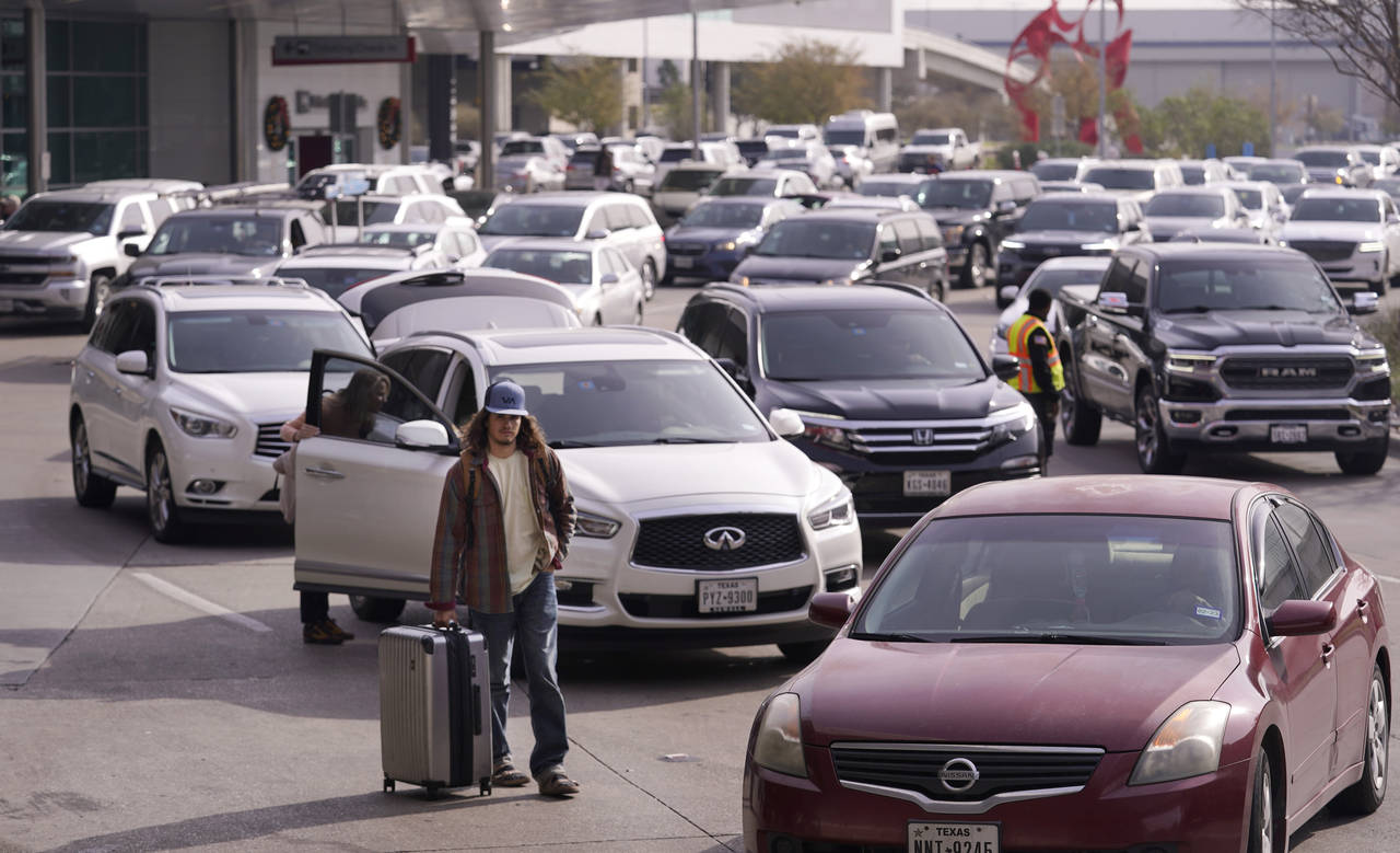 Cars line up to pick up travelers at Love Field Airport in Dallas, Wednesday, Dec. 21, 2022. (AP Ph...