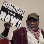 
              Morris Griffin holds up a sign during a meeting by the Task Force to Study and Develop Reparation Proposals for African Americans in Oakland, Calif., Wednesday, Dec. 14, 2022. (AP Photo/Jeff Chiu)
            