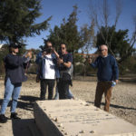
              Israeli peace activist gather around the grave of Baruch Goldstein, an Israeli-American religious extremist, in Kiryat Arba, a Jewish settlement on the outskirts of of the embattled West Bank city of Hebron, Friday, Dec. 2, 2022. Israeli peace activists toured the occupied West Bank's largest city Friday in a show of solidarity with Palestinians, amid chants of "shame, shame" from ultra-nationalist hecklers.The encounter in the center of Hebron signaled the widening rift among Israelis over the nature of their society and Israel's open-ended military rule over the Palestinians, now in its 56th year. (AP Photo/Maya Alleruzzo)
            