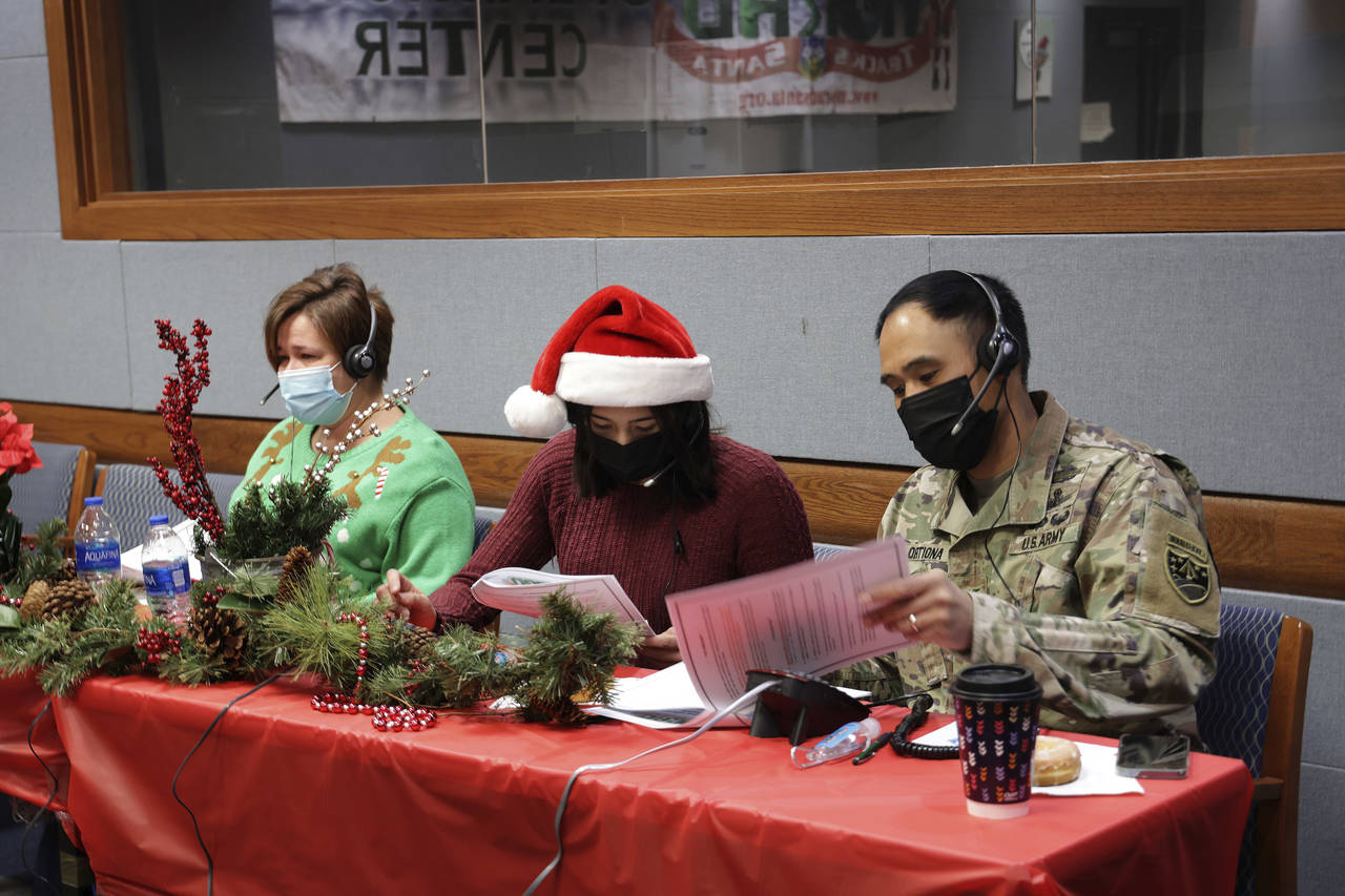 In this photo released by the U.S. Department of Defense, volunteers answer phones and emails from ...