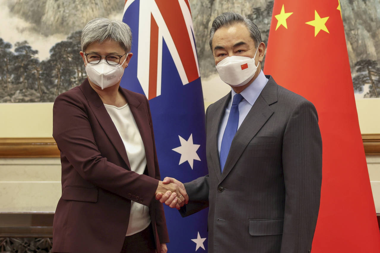 Australian Foreign Minister Penny Wong shakes hands with Chinese Foreign Minister Wang Yi in Beijin...