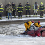 
              Kansas City fire department rescue workers work to recover a minivan that went into Brush Creek in Kansas City, Mo., on Thursday, Dec. 22, 2022. Police say the driver lost control of the minivan on an icy street and the vehicle went down an embankment and overturned before submerging in Brush Creek. The driver was pulled from the creek but died later at a hospital. (Nick Wagner/The Kansas City Star via AP)
            