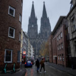 
              Two men walk along a street near the Cologne Cathedral in Cologne, Germany, Wednesday, Nov. 30, 2022. An unprecedented crisis of confidence is shaking the Archdiocese of Cologne. Catholic believers have protested their deeply divisive bishop and are leaving in droves over allegations that he may have covered up clergy sexual abuse reports. (AP Photo/Michael Probst)
            