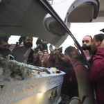 
              Mourners are seen around the coffin of late Kostas Frangoulis during a funeral procession in northern city of Thessaloniki, Greece, on Thursday, Dec. 15, 2022. About 1,500 mourners gathered Thursday in a Roma settlement in northern Greece for the funeral of a 16-year-old who died days after being shot in the head by police during a car chase over an unpaid gas station bill. (AP Photo/Giannis Papanikos)
            