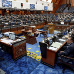 In this photo provided by Prime Minister Office, Malaysia's Prime Minister Anwar Ibrahim, bottom right, joins the lawmakers on the first session of the parliament in Kuala Lumpur, Malaysia, Monday, Dec. 19, 2022. (Prime Minister office via AP)