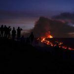 
              People watch and record images of lava from the Mauna Loa volcano Thursday, Dec. 1, 2022, near Hilo, Hawaii. (AP Photo/Gregory Bull)
            