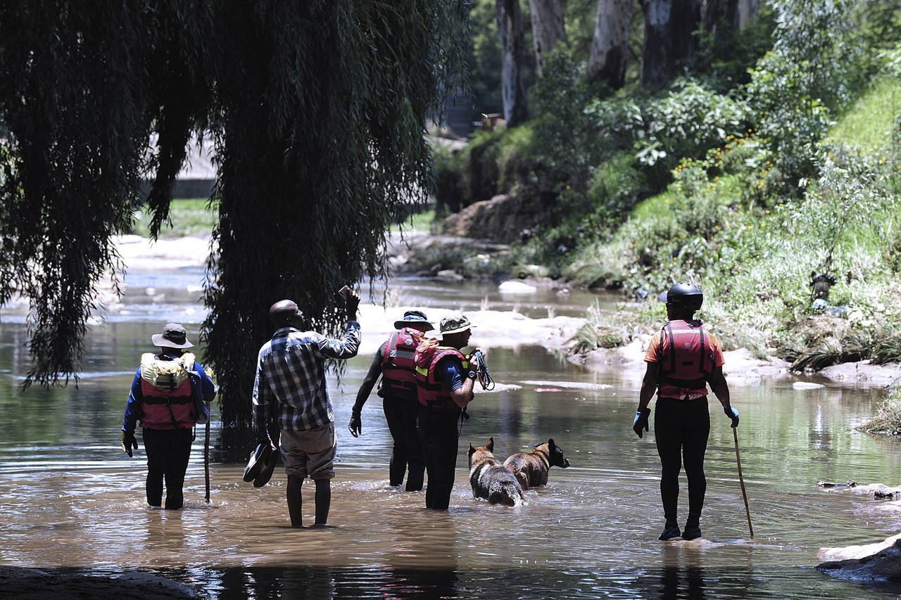 Rescue workers search the waters of the Jukskei river in Johannesburg, Sunday, Dec. 4, 2022. At lea...