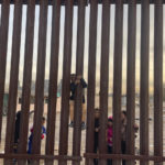
              A few miles west of where the Texas National Guard deployed on the U.S.-Mexico border, a few children play by the fence on the Mexican side in the desert scrub across from Sunland Park, N.M., Tuesday, Dec. 20, 2022. (AP Photo/Giovanna Dell'Orto)
            