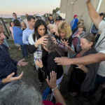 
              FILE - Amanda Grace of Ark of Grace Ministries and a group of people gather in prayer around a woman for the laying of hands during the ReAwaken America Tour at Cornerstone Church in Batavia, N.Y., Aug. 12, 2022. (AP Photo/Carolyn Kaster, File)
            