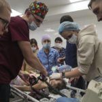 
              FILE - Nurse Dmytro Gavro, left, with his colleagues perform CPR on a girl fatally injured during the shelling of a residential area, in the city hospital of Mariupol, eastern Ukraine, Sunday, Feb. 27, 2022. A team of doctors and nurses who fled Mariupol as Russian forces closed in on their hospital are starting up a new medical center in the Ukrainian capital to serve people displaced by the war. Around 30 staff from Mariupol's Hospital Number 2 and a team of cardiac specialists who rescued their equipment from shelling in the eastern city of Kramatorsk started taking patients on Tuesday, Dec. 13, 2022. (AP Photo/Evgeniy Maloletka, File)
            