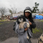 
              CORRECTS LAST NAME TO BOVIE NOT BOVIEM - Chelsi Bovie holds her niece's dog that she rescued from her home after a tornado tore through the area in Killona, La., about 30 miles west of New Orleans in St. James Parish, Wednesday, Dec. 14, 2022. (AP Photo/Gerald Herbert)
            