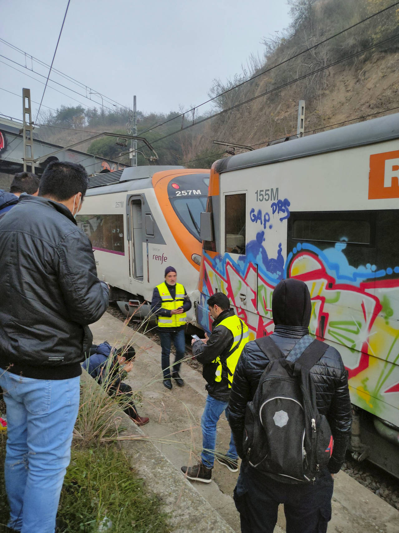 Passengers and railway staff are seen at the scene of a train collision in Montcada i Reixac, Spain...