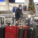 
              Airport staff looks around a pile of lost suitcases near the baggage carousel at Midway Airport in Chicago, Tuesday, Dec. 27, 2022, after Southwest Airlines flights were cancelled and delayed during a winter storm. Problems at Southwest Airlines appeared to snowball after the worst of the storm passed. It cancelled more than 70% of its flights Monday, more than 60% on Tuesday, and warned that it would operate just over a third of its usual schedule in the days ahead to allow crews to get back to where they needed to be. (Pat Nabong /Chicago Sun-Times via AP)
            