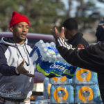 
              Dontavious Spann, left, with the Mississippi Rapid Response Coalition, and volunteer Preston Alston of Jackson, Miss., help to distribute water to Jackson residents near Northside Drive and Manhattan Road on Tuesday, Dec. 27, 2022. Three days after a hard freeze resulted in broken pipes and low water pressure, Mayor Chokwe Antar Lumumba declared a a local state of emergency. (Barbara Gauntt/The Clarion-Ledger via AP)
            