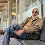 
              Conrad Stoll, a 66-year-old retired construction worker who lives near Nevada, Mo., waits at the Kansas City International Airport in Kansas City, Mo., for his wife to pick him up after his Southwest flight to Los Angeles was canceled early Tuesday, Dec. 27, 2022. He had planned to make the trip so he could attend his father's 90th birthday party and see his 88-year-old mother. (AP Photo/Heather Hollingsworth)
            