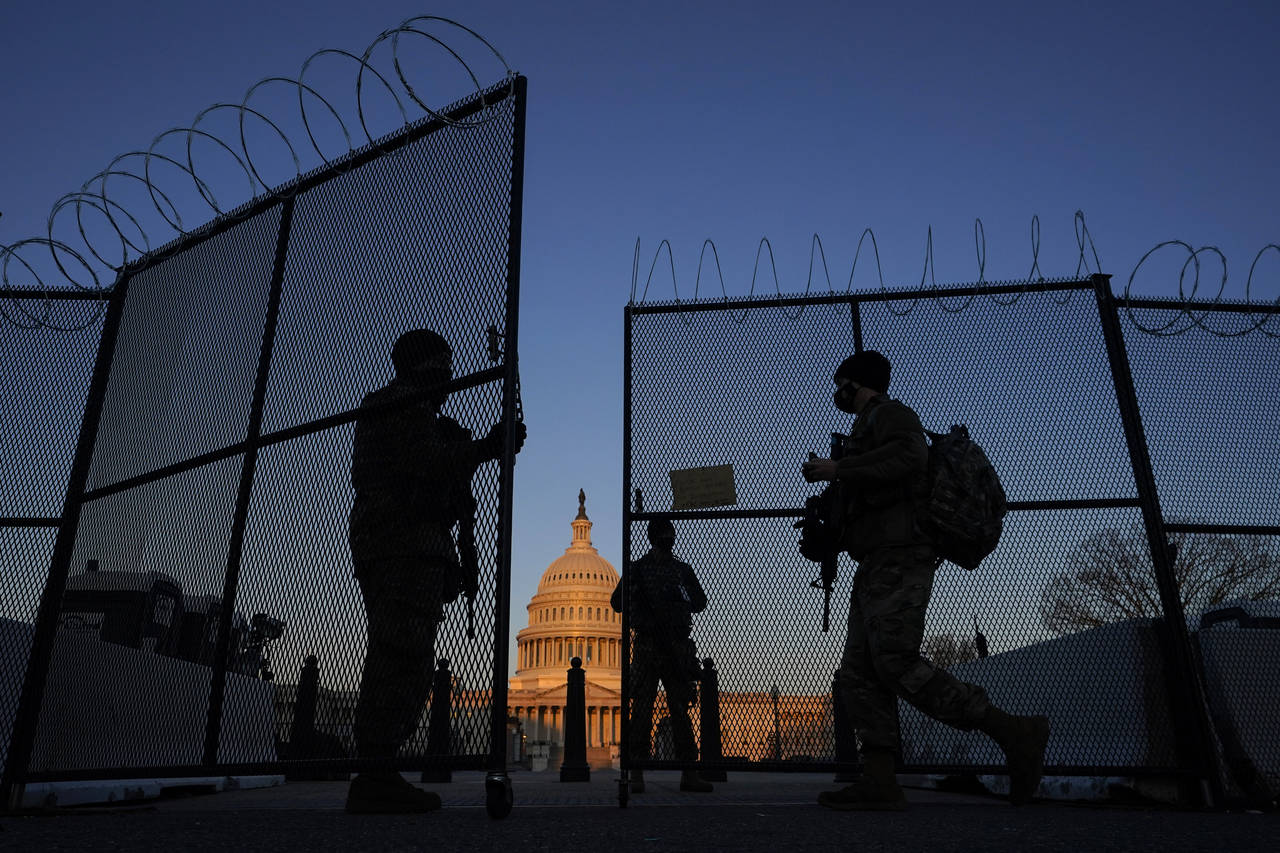 FILE - National Guard soldiers open a gate of the razor wire-topped perimeter fence around the Capi...